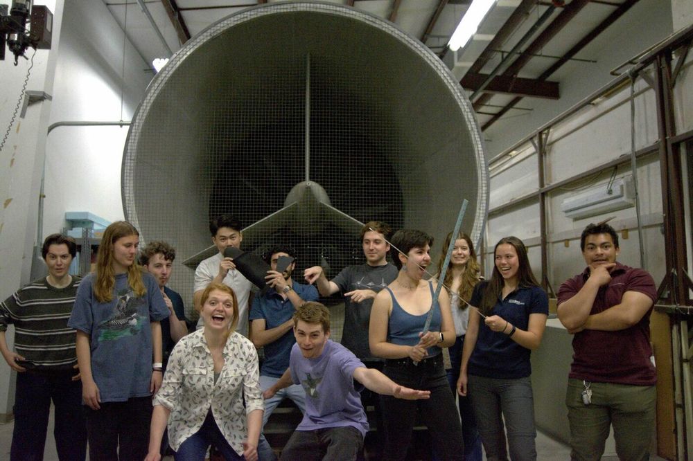 The BIRD Lab group being playful in front of a large wind tunnel